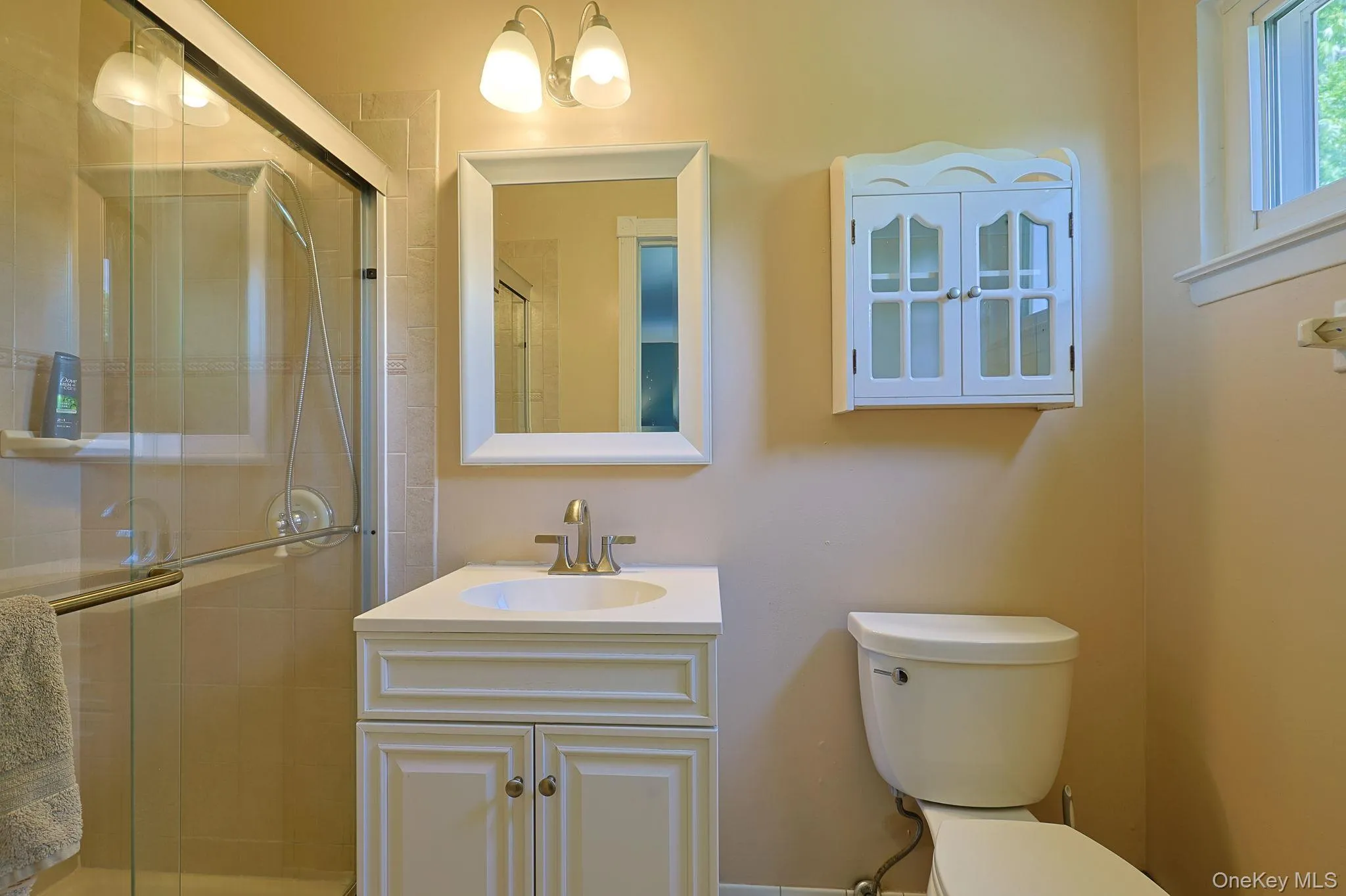 Primary bathroom featuring a tiled shower with sliding glass doors. Primary bathroom featuring a tiled shower with sliding glass doors.