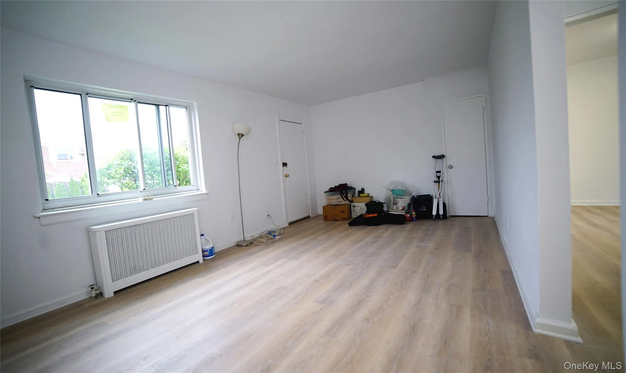Spare room with radiator, baseboards, and light wood-type flooring Spare room with radiator, baseboards, and light wood-type flooring