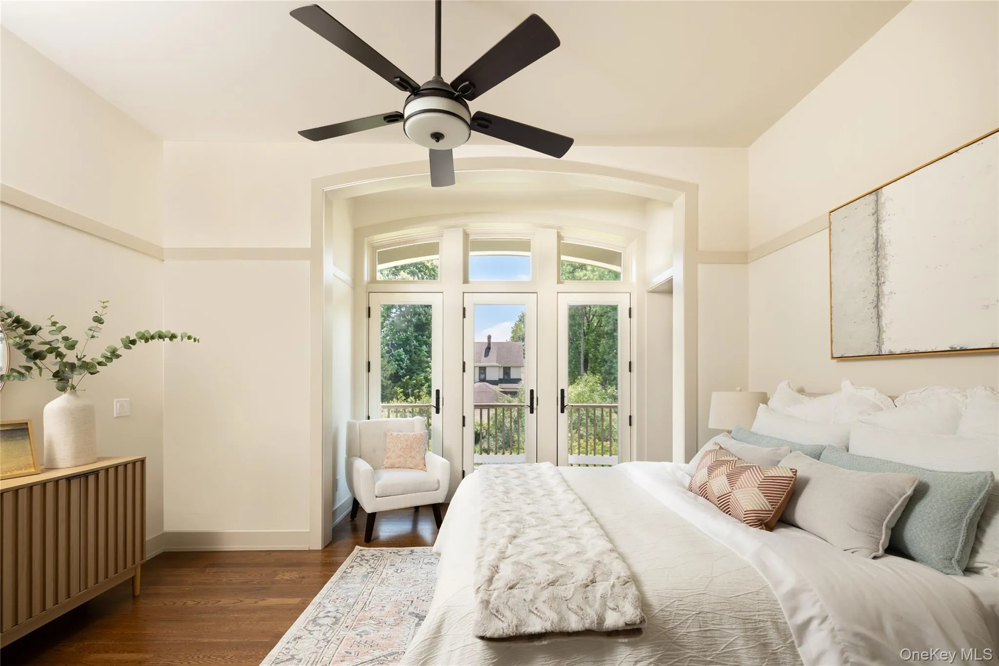Primary bedroom with arched-topped French doors to balcony Primary bedroom with arched-topped French doors to balcony