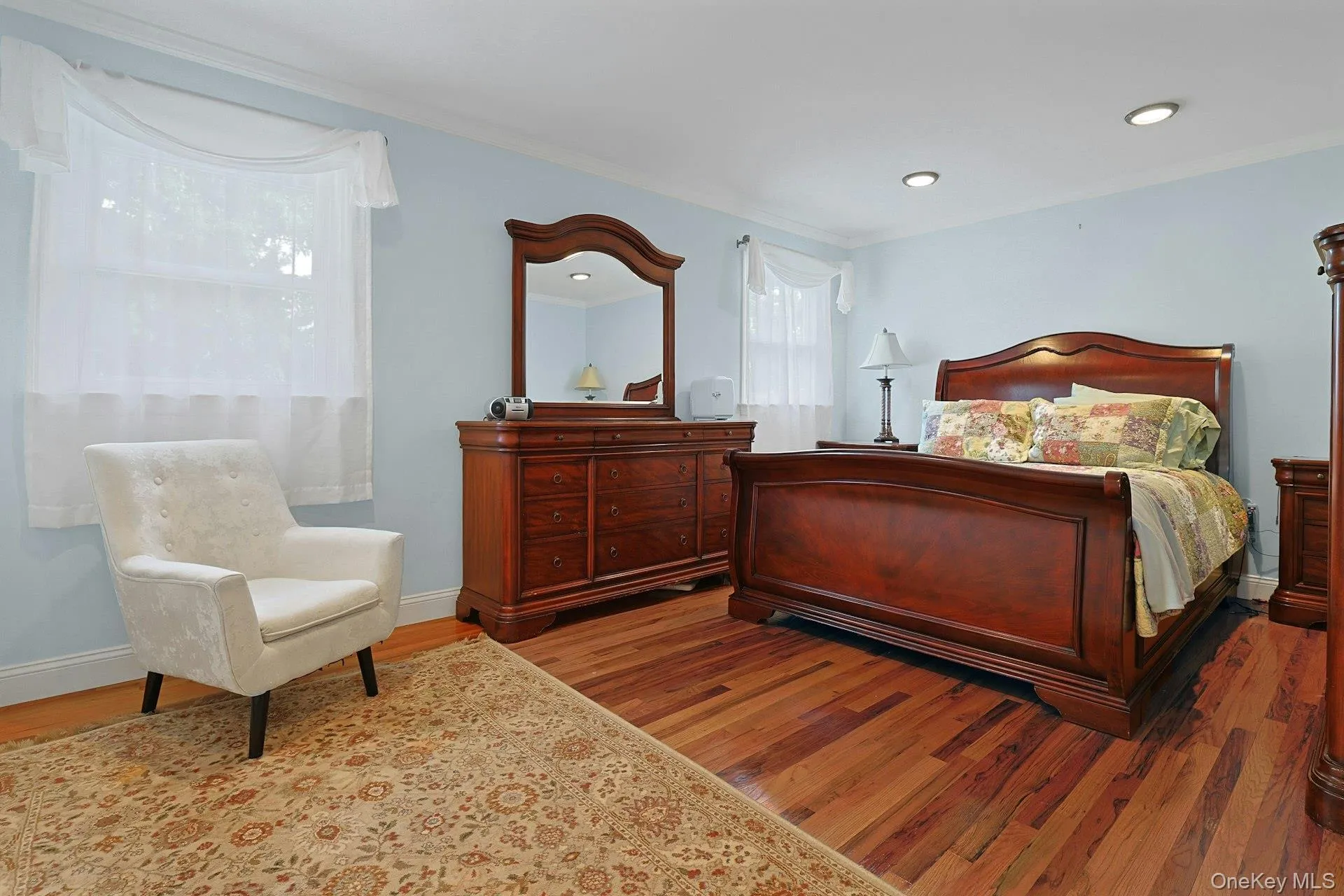 Room featuring wood-finish flooring, light blue wall paint, and white trim Room featuring wood-finish flooring, light blue wall paint, and white trim