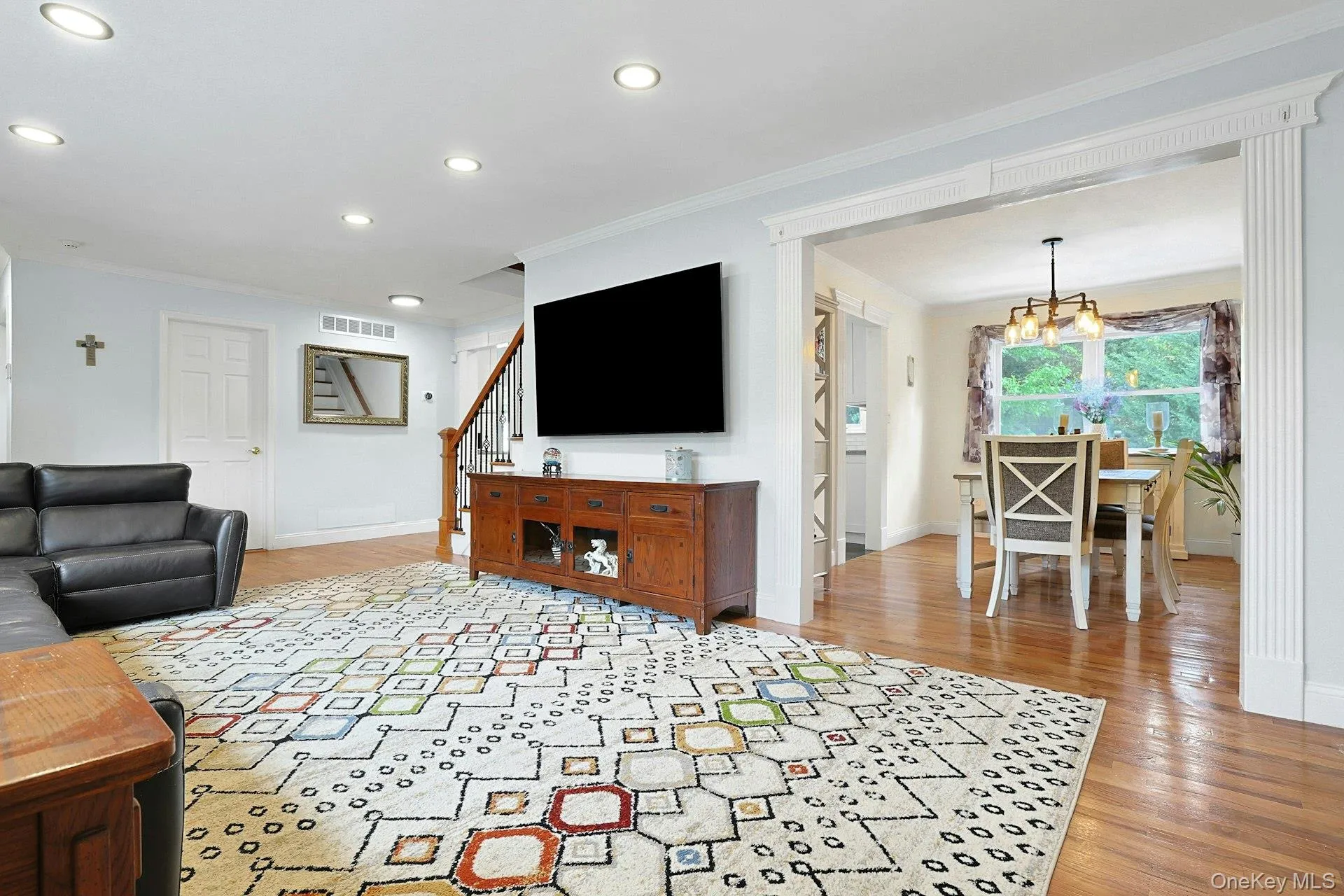 Expansive living space featuring recessed lighting and wood-finish flooring Expansive living space featuring recessed lighting and wood-finish flooring