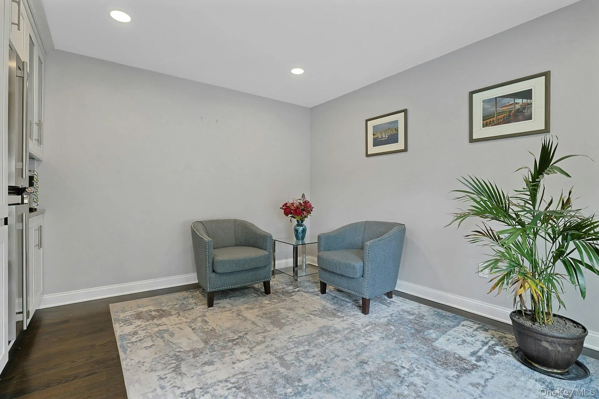 Recessed lighting illuminates this space featuring dark wood-finish flooring, light grey walls, and white baseboards Recessed lighting illuminates this space featuring dark wood-finish flooring, light grey walls, and white baseboards