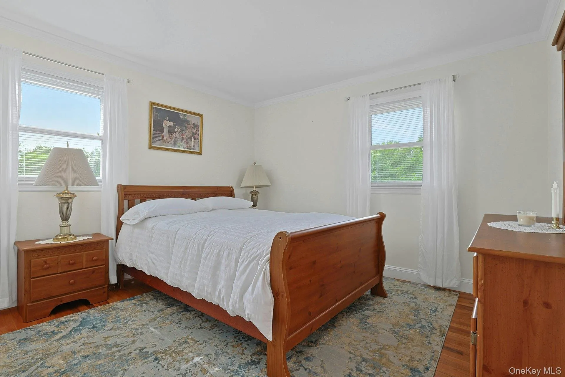 Bright room featuring two windows with horizontal blinds and sheer white curtains Bright room featuring two windows with horizontal blinds and sheer white curtains