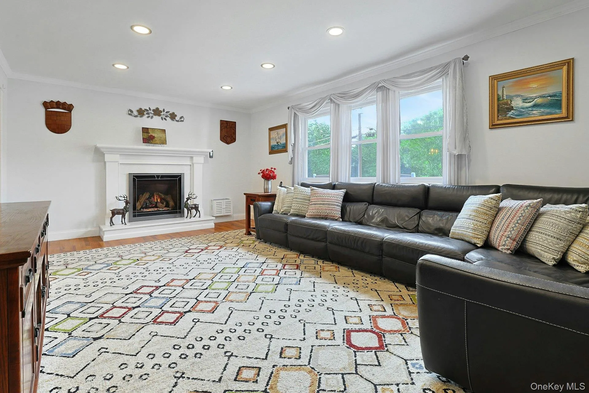 Spacious living area featuring a prominent fireplace with a classic white mantel Spacious living area featuring a prominent fireplace with a classic white mantel