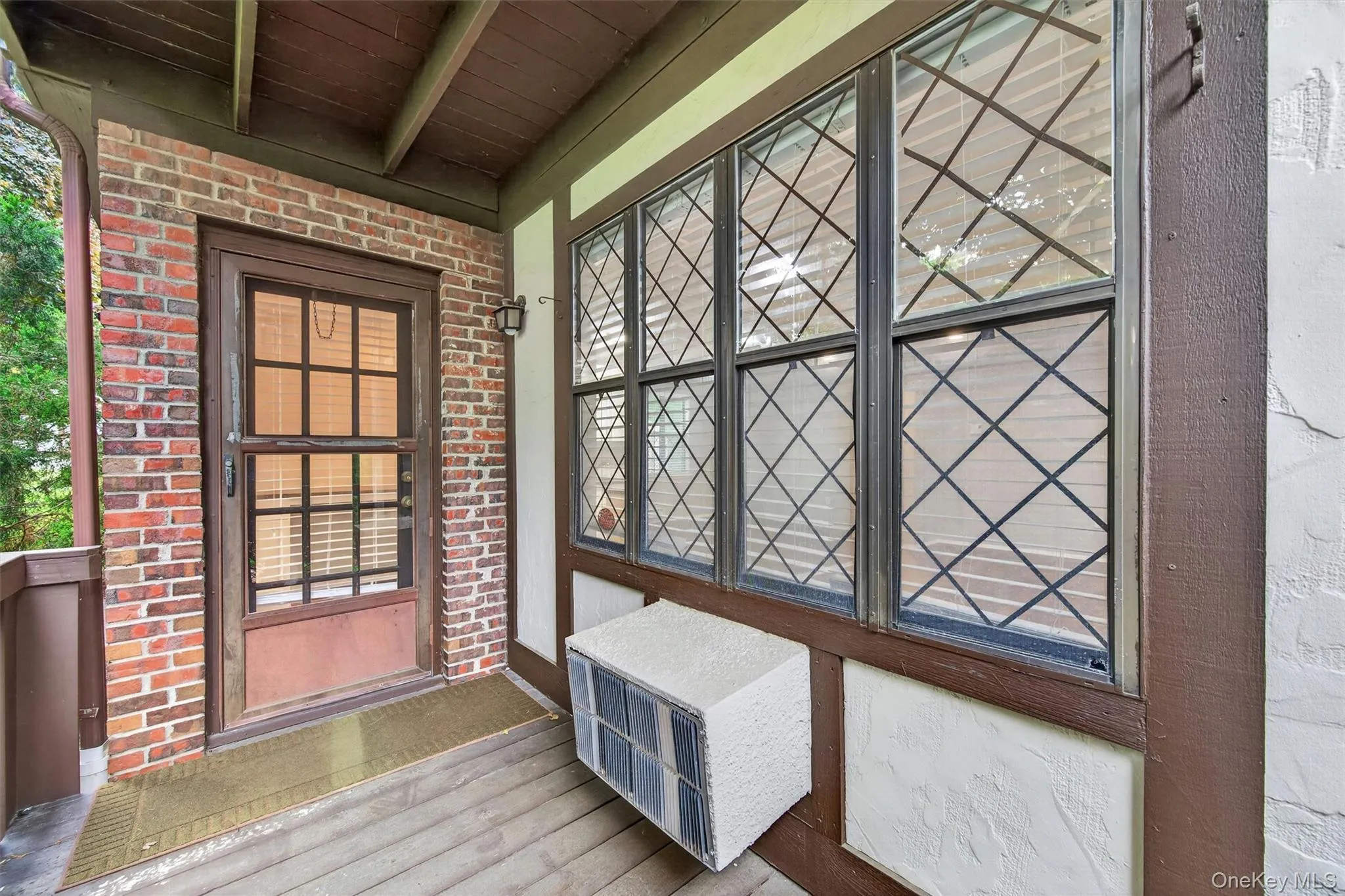 Brick exterior featuring a wood entry door with glass panels Brick exterior featuring a wood entry door with glass panels