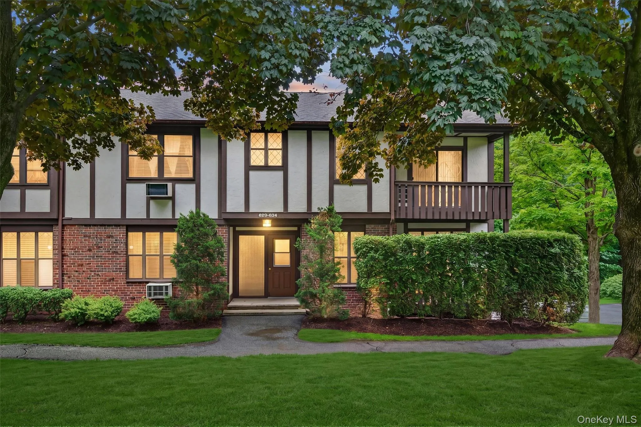 Tudor-style exterior featuring brick and white siding with dark trim accents Tudor-style exterior featuring brick and white siding with dark trim accents