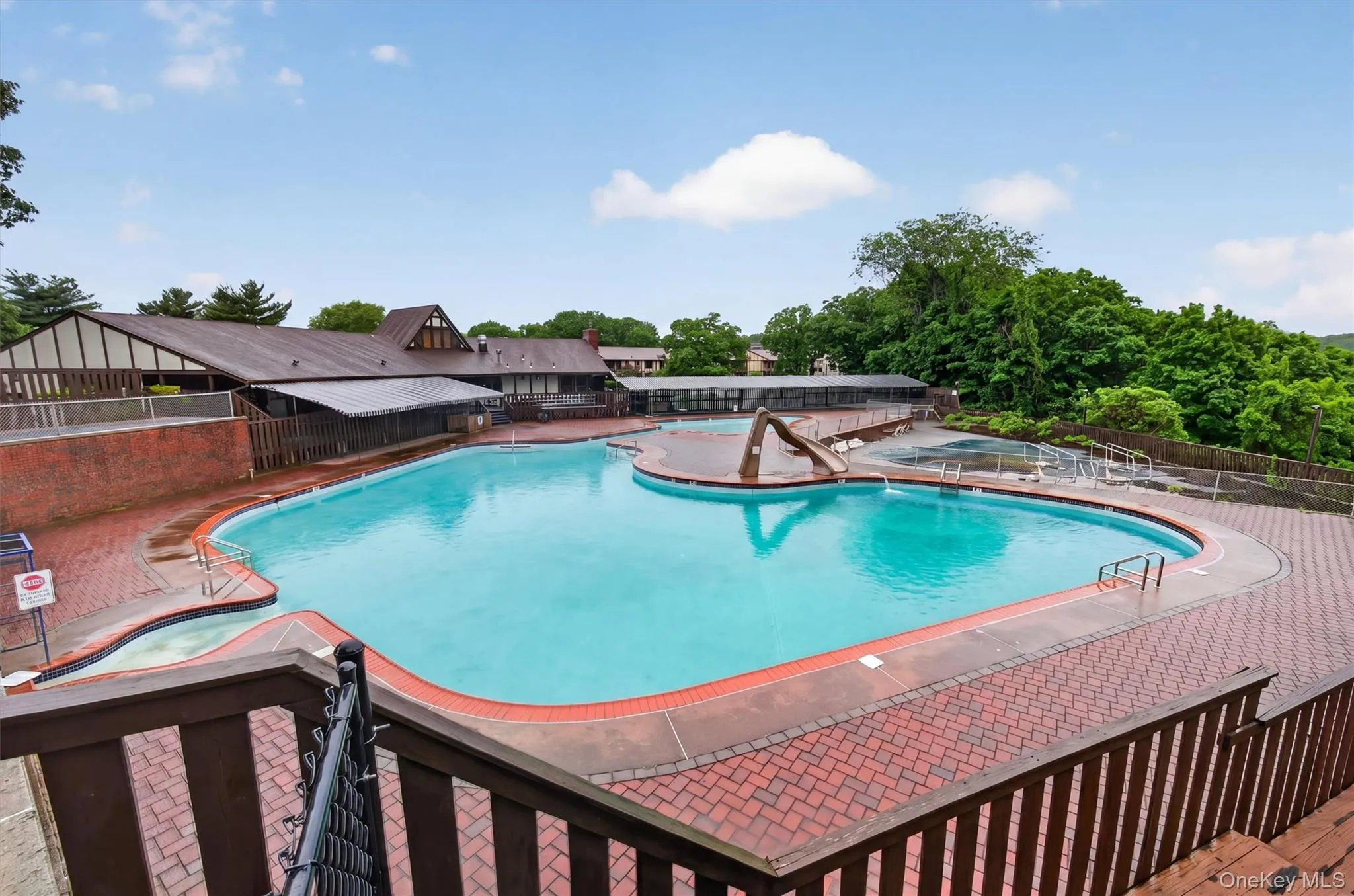 Expansive outdoor swimming pool with surrounding brick paver deck Expansive outdoor swimming pool with surrounding brick paver deck
