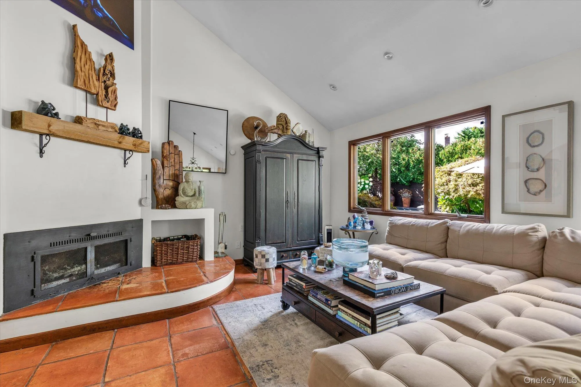 Tiled living area featuring a fireplace with raised hearth, high vaulted ceiling, and recessed lighting Tiled living area featuring a fireplace with raised hearth, high vaulted ceiling, and recessed lighting