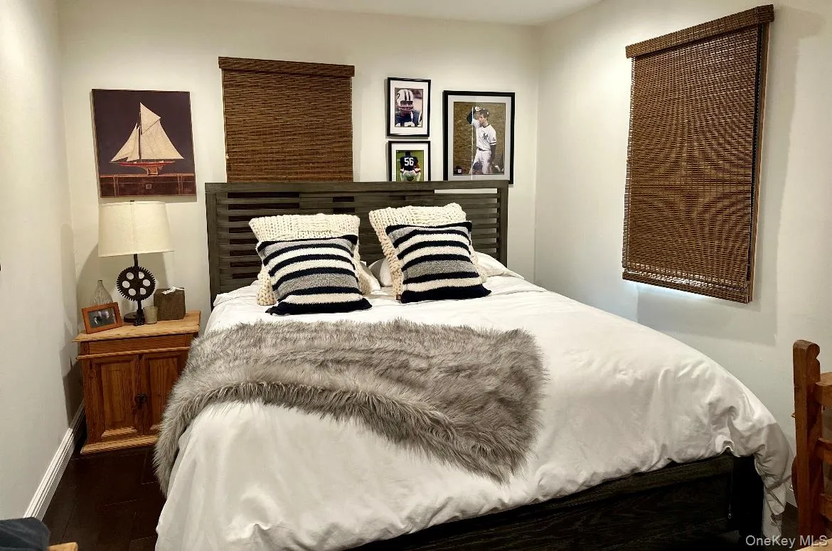 Bedroom featuring baseboards and dark wood-style flooring Bedroom featuring baseboards and dark wood-style flooring