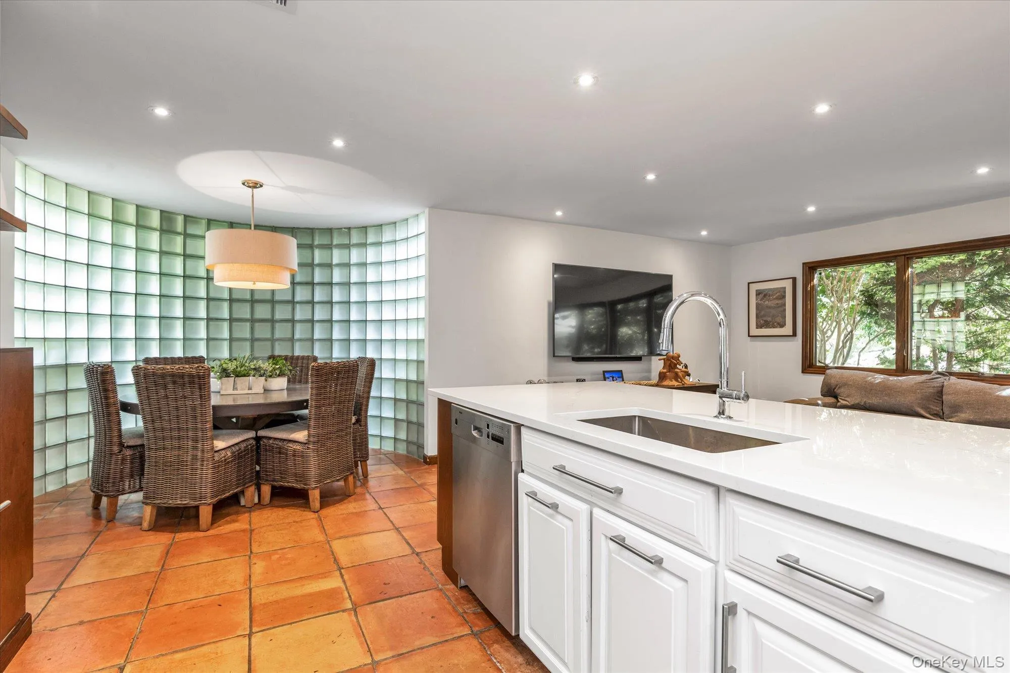 Kitchen featuring white cabinets, recessed lighting, light stone countertops, stainless steel dishwasher, and light tile patterned flooring Kitchen featuring white cabinets, recessed lighting, light stone countertops, stainless steel dishwasher, and light tile patterned flooring