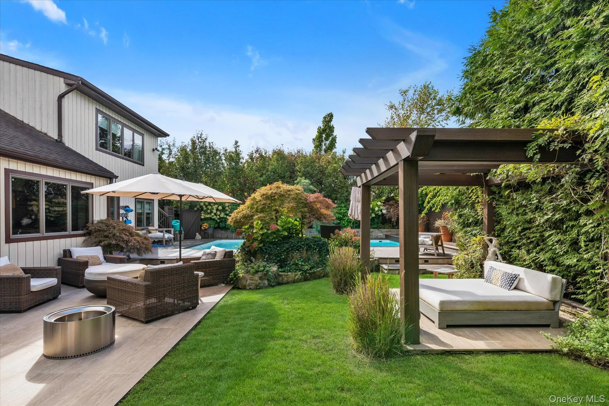 View of grassy yard with outdoor lounge area, an outdoor pool, a patio area, and a wooden deck View of grassy yard with outdoor lounge area, an outdoor pool, a patio area, and a wooden deck