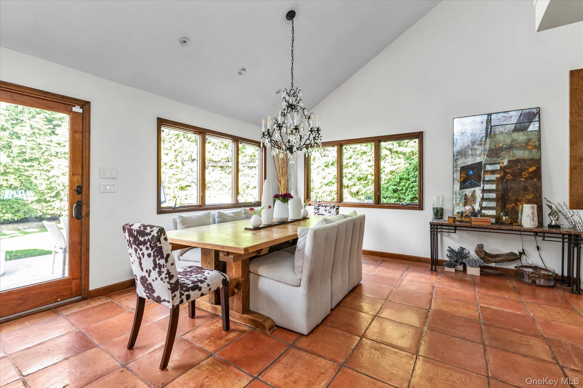 Dining room with high vaulted ceiling, healthy amount of natural light, and a chandelier Dining room with high vaulted ceiling, healthy amount of natural light, and a chandelier
