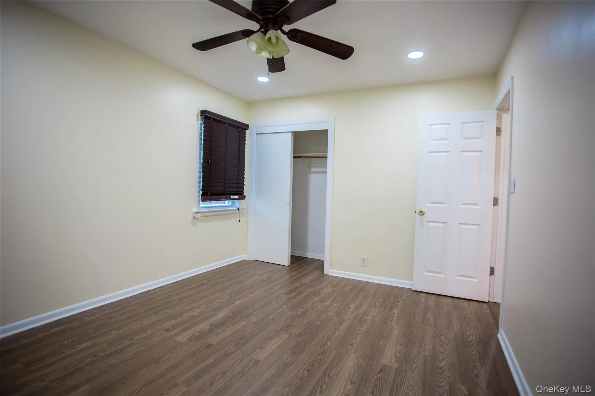 Unfurnished bedroom with recessed lighting, dark wood finished floors, a closet, and baseboards Unfurnished bedroom with recessed lighting, dark wood finished floors, a closet, and baseboards