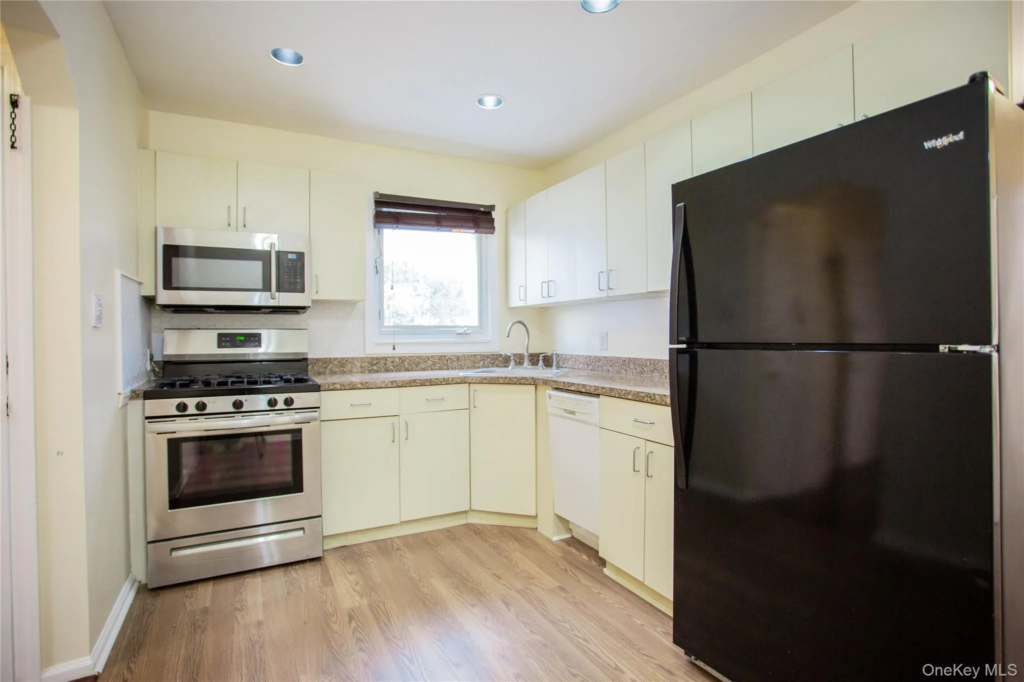 Kitchen with recessed lighting, stainless steel appliances, light countertops, a sink, and light wood-type flooring Kitchen with recessed lighting, stainless steel appliances, light countertops, a sink, and light wood-type flooring