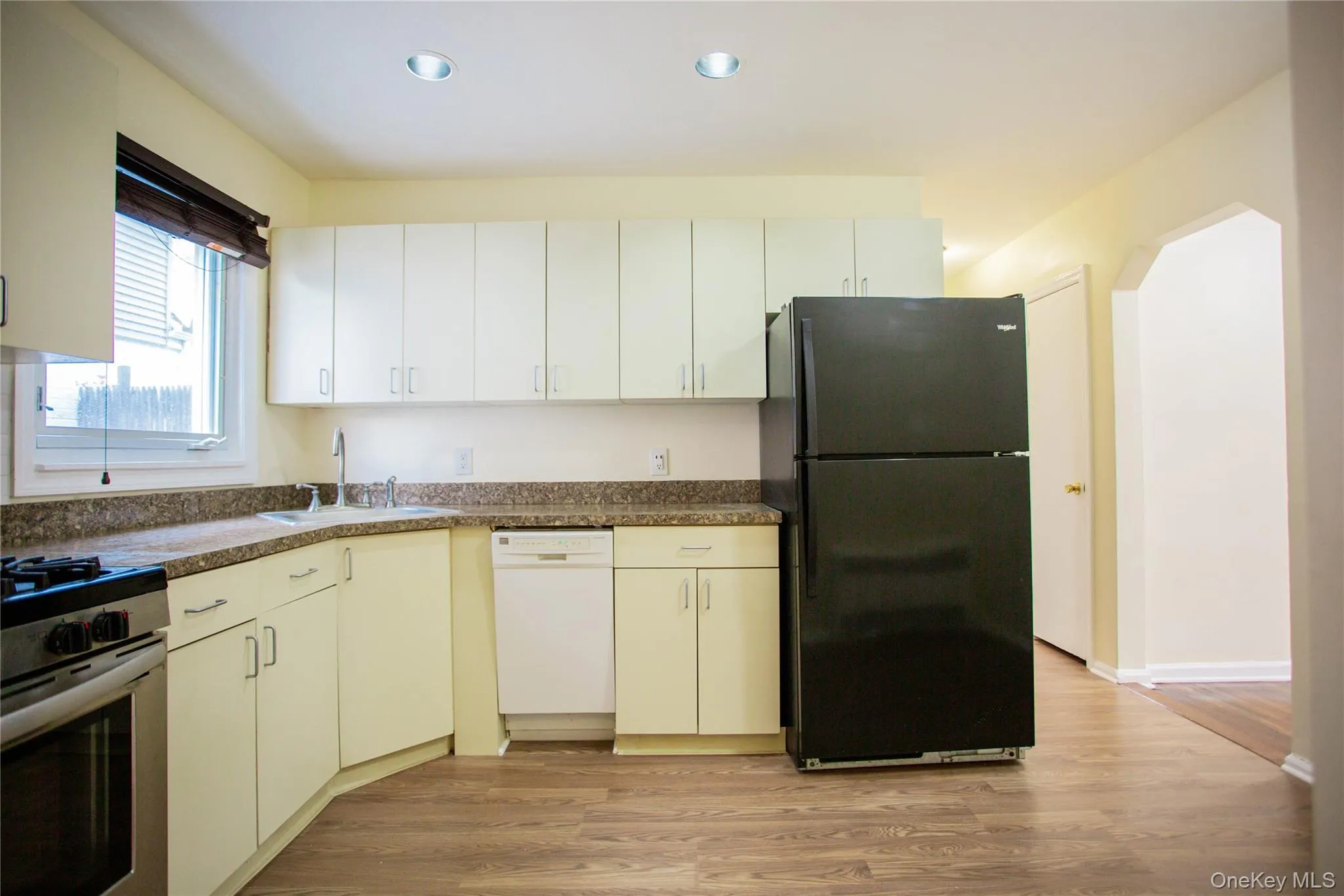 Kitchen featuring stainless steel range with gas cooktop, white dishwasher, a sink, freestanding refrigerator, and recessed lighting Kitchen featuring stainless steel range with gas cooktop, white dishwasher, a sink, freestanding refrigerator, and recessed lighting