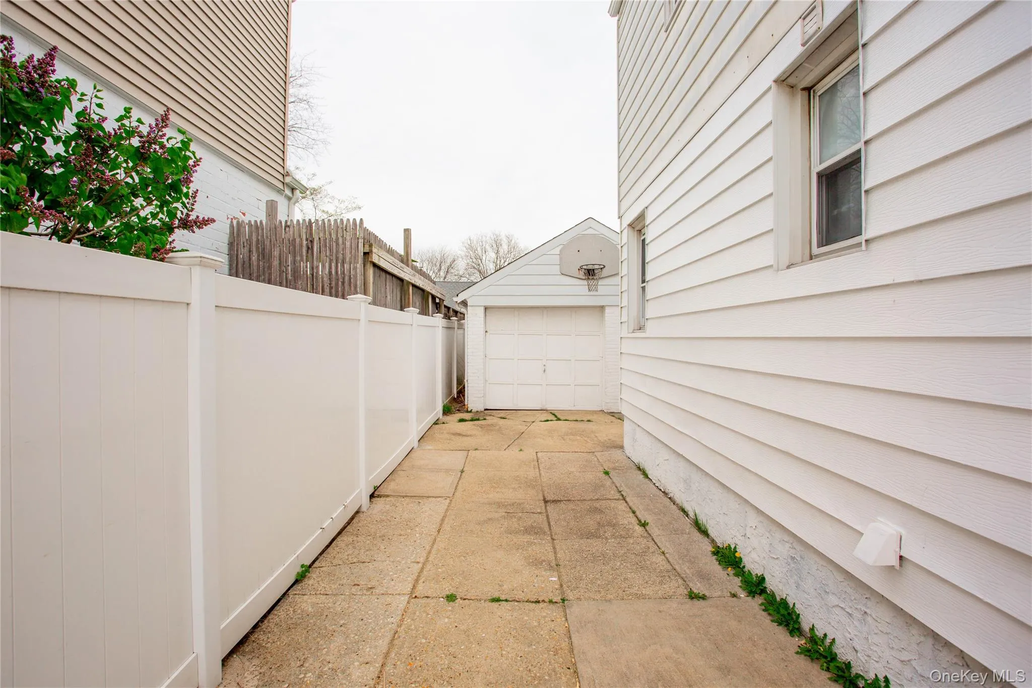 View of side of home featuring fence, an outbuilding, and a detached garage View of side of home featuring fence, an outbuilding, and a detached garage