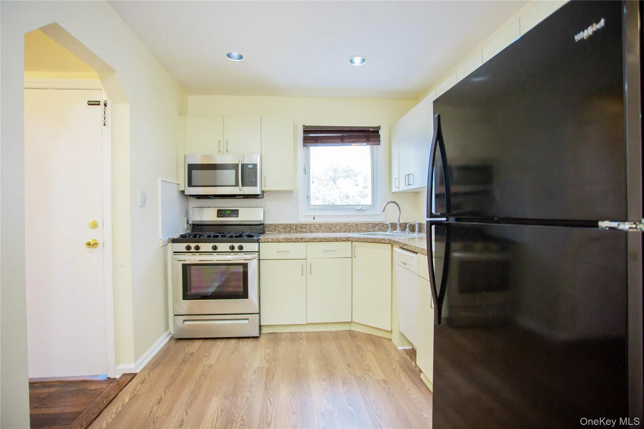Kitchen with a sink, light countertops, stainless steel appliances, light wood-style flooring, and recessed lighting Kitchen with a sink, light countertops, stainless steel appliances, light wood-style flooring, and recessed lighting