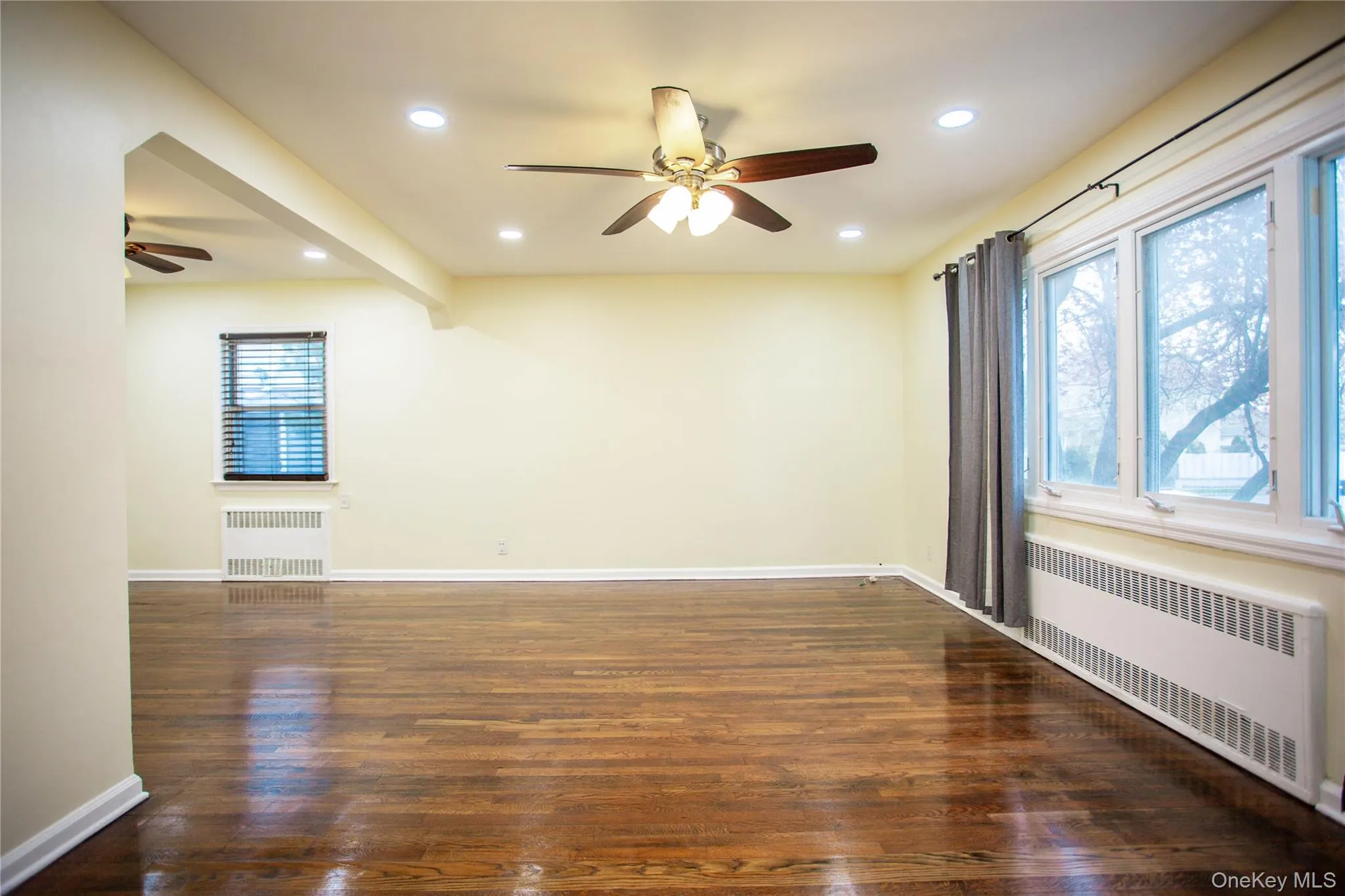Empty room featuring radiator, baseboards, ceiling fan, and recessed lighting Empty room featuring radiator, baseboards, ceiling fan, and recessed lighting