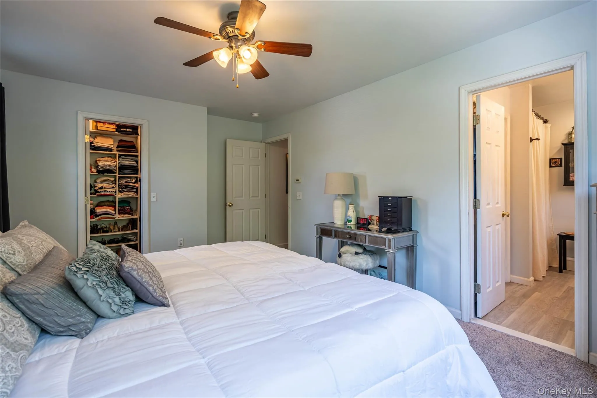 Bedroom with carpet floors, a spacious closet, and ceiling fan Bedroom with carpet floors, a spacious closet, and ceiling fan