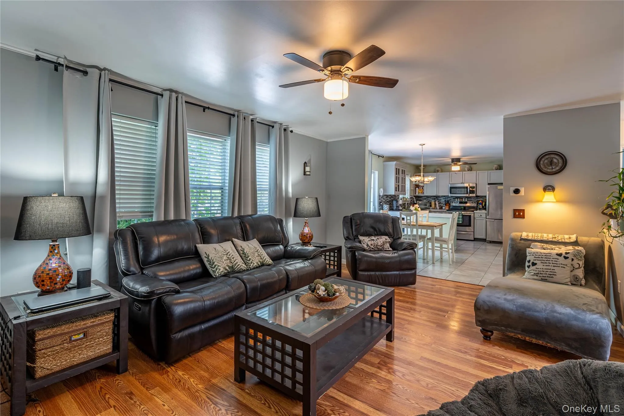 Living room featuring a ceiling fan and light wood-type flooring Living room featuring a ceiling fan and light wood-type flooring