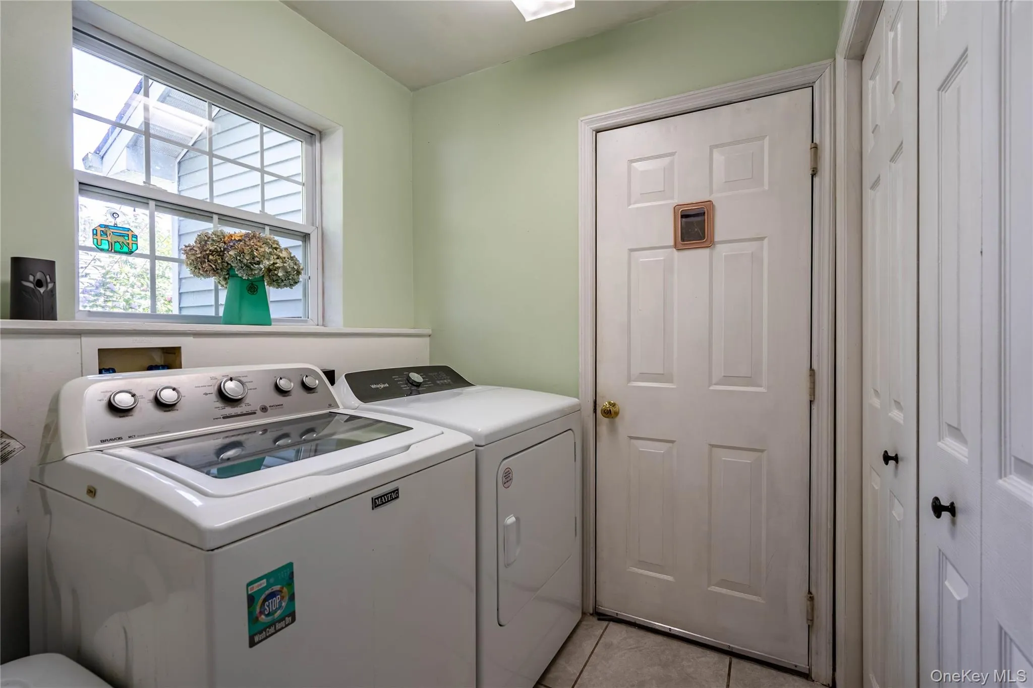 Laundry room featuring light tile patterned flooring and separate washer and dryer Laundry room featuring light tile patterned flooring and separate washer and dryer