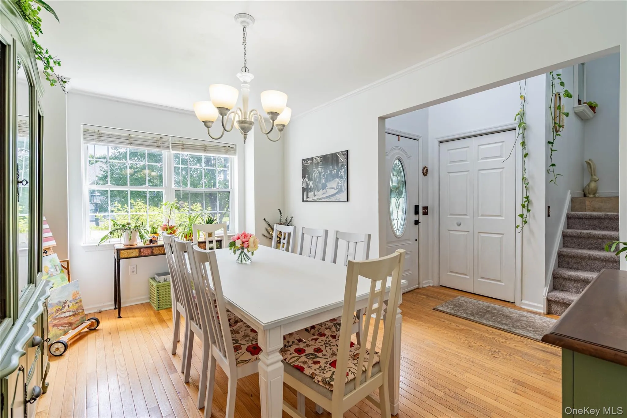 Dining space with light wood-style floors, stairs, plenty of natural light, and crown molding Dining space with light wood-style floors, stairs, plenty of natural light, and crown molding