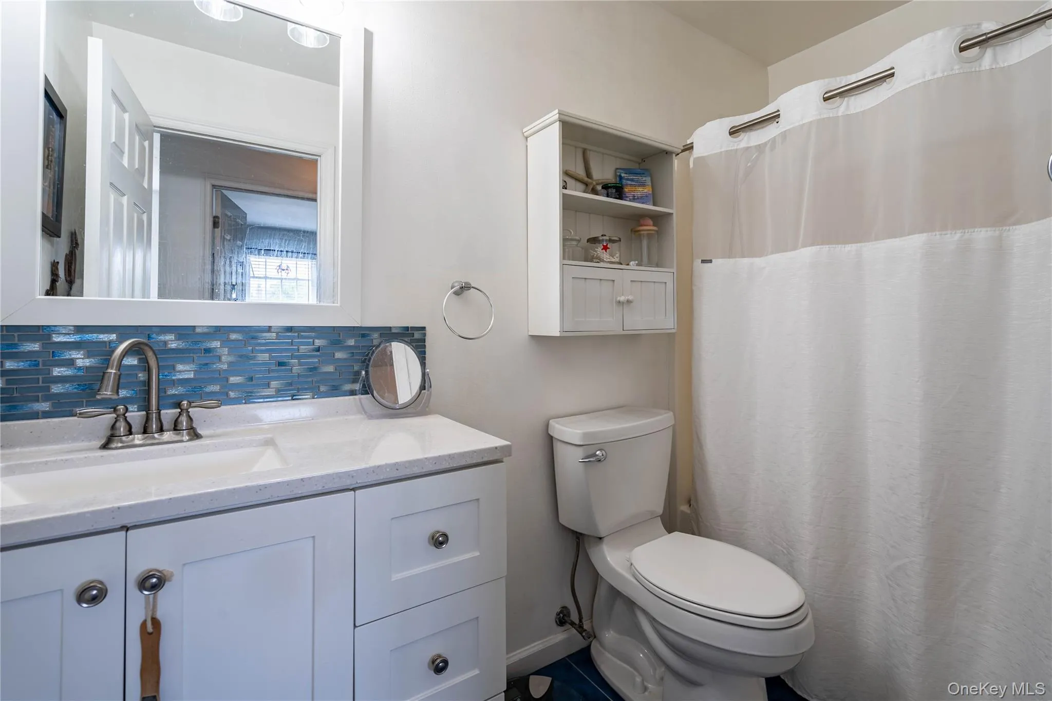 Full bath featuring vanity, backsplash, and curtained shower Full bath featuring vanity, backsplash, and curtained shower