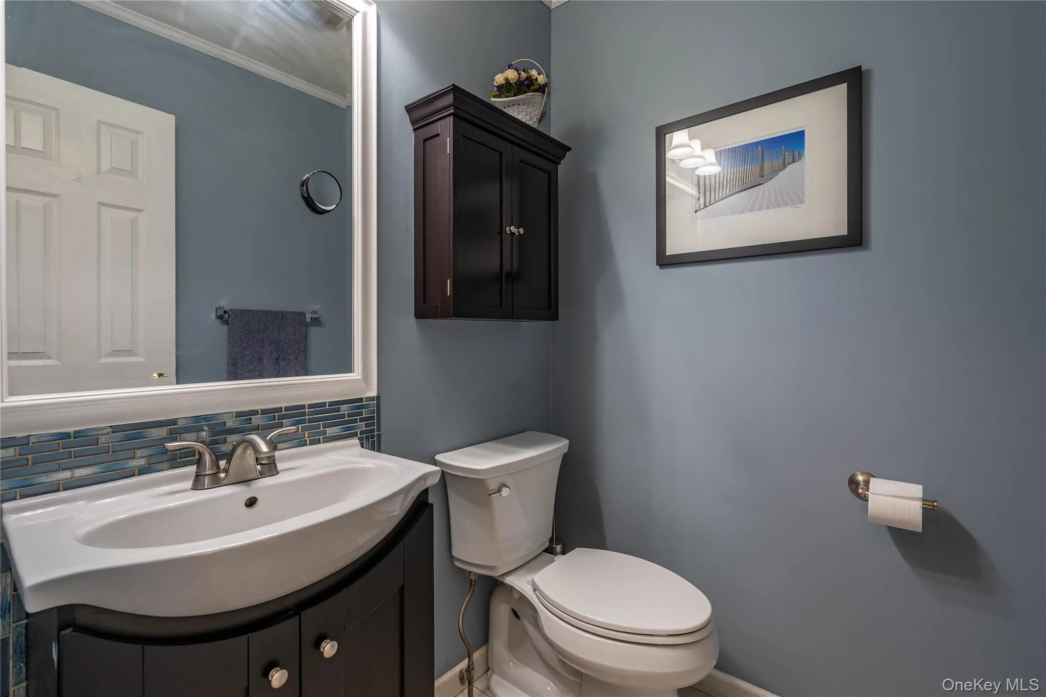Half bathroom featuring vanity, backsplash, and ornamental molding Half bathroom featuring vanity, backsplash, and ornamental molding