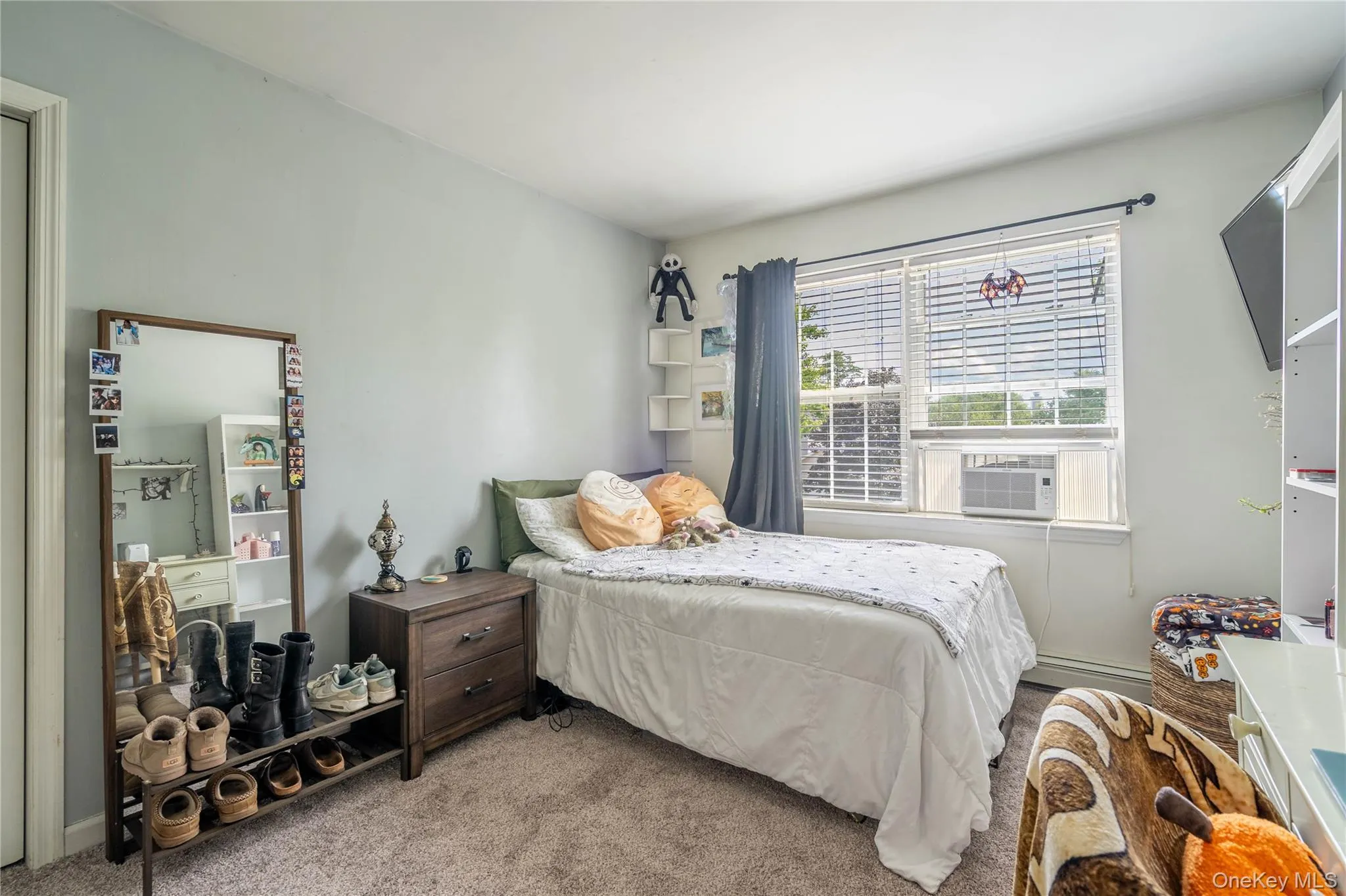 Carpeted bedroom featuring cooling unit and a baseboard heating unit Carpeted bedroom featuring cooling unit and a baseboard heating unit