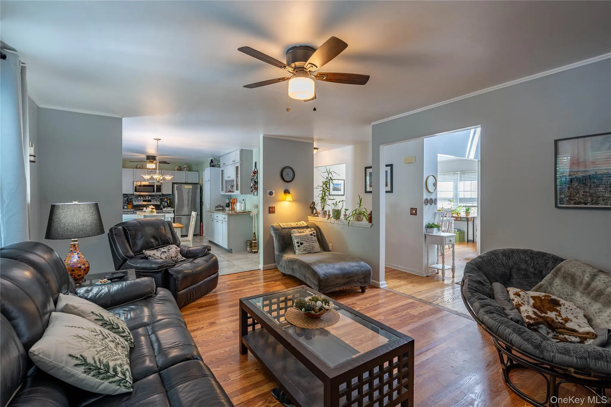 Living area with a ceiling fan, crown molding, and wood finished floors Living area with a ceiling fan, crown molding, and wood finished floors