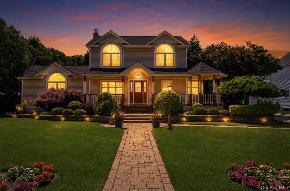 Traditional-style residence featuring a prominent gabled roofline, arched windows, and a covered front porch Traditional-style residence featuring a prominent gabled roofline, arched windows, and a covered front porch
