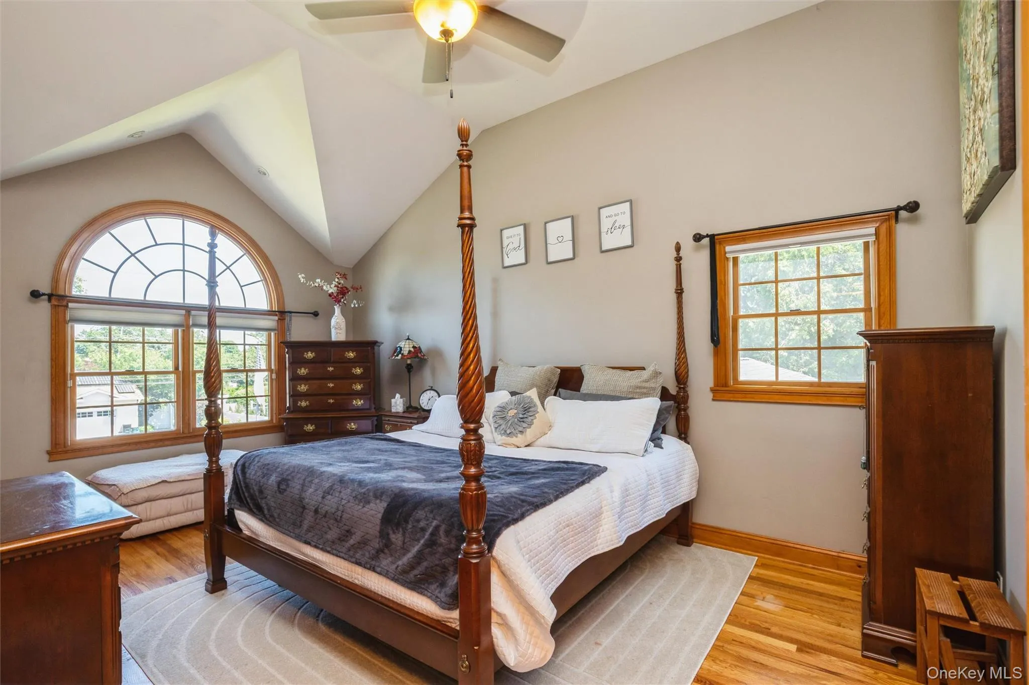 Vaulted ceiling room featuring a large arched window, hardwood flooring, and a ceiling fan with integrated lighting Walkin closet plus another Vaulted ceiling room featuring a large arched window, hardwood flooring, and a ceiling fan with integrated lighting Walkin closet plus another