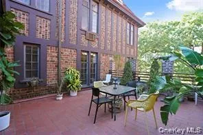 Expansive outdoor patio featuring brick pavers, a low brick and metal railing, and direct access to the interior through a series of glass-paned doors Expansive outdoor patio featuring brick pavers, a low brick and metal railing, and direct access to the interior through a series of glass-paned doors