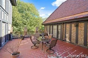 Expansive outdoor patio featuring brick pavers, a low brick and metal railing, and direct access to the interior through a series of glass-paned doors Expansive outdoor patio featuring brick pavers, a low brick and metal railing, and direct access to the interior through a series of glass-paned doors