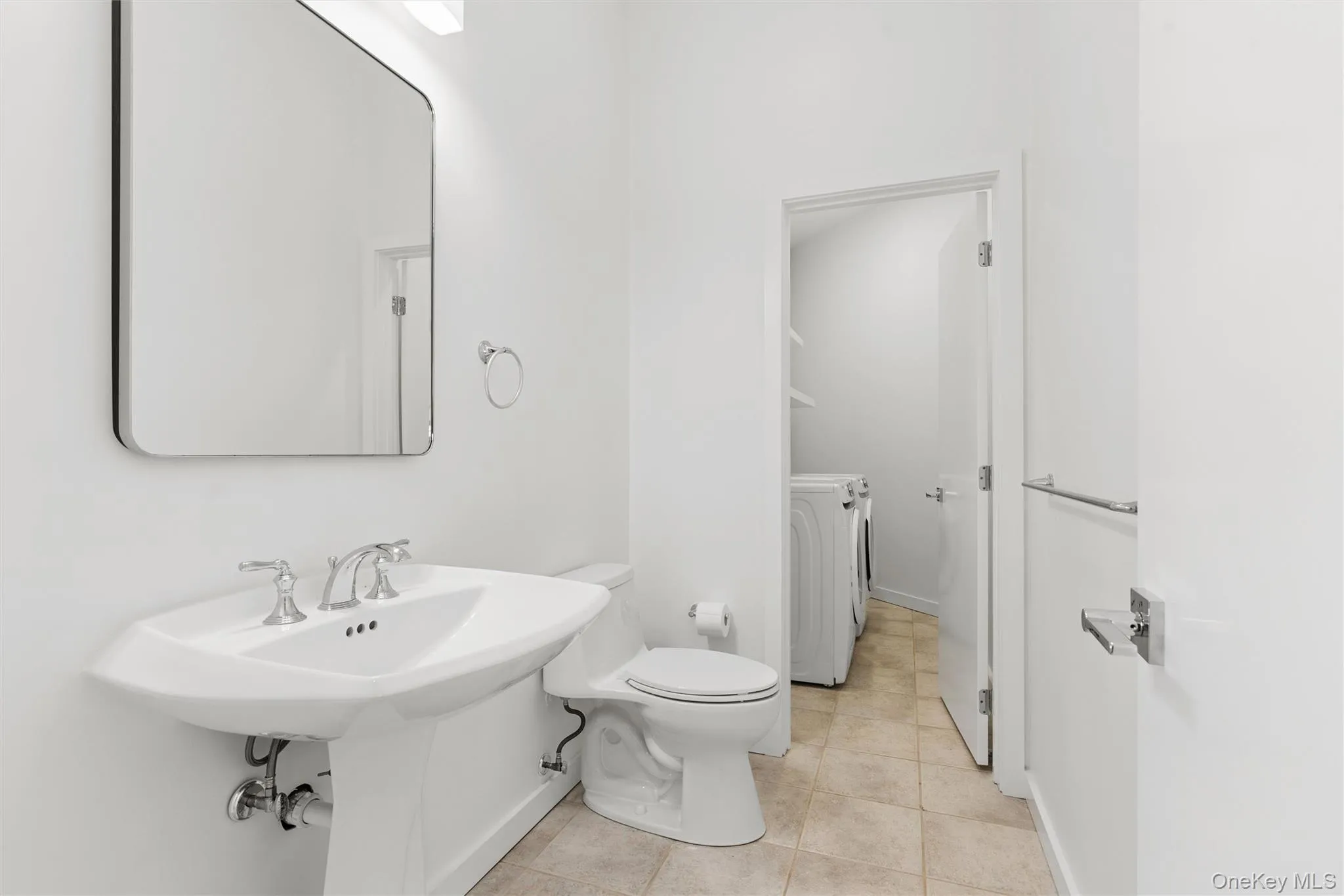 2nd Floor Pedestal sink with chrome fixtures, a wall-mounted mirror, and tile flooring leading to washer and dryer 2nd Floor Pedestal sink with chrome fixtures, a wall-mounted mirror, and tile flooring leading to washer and dryer