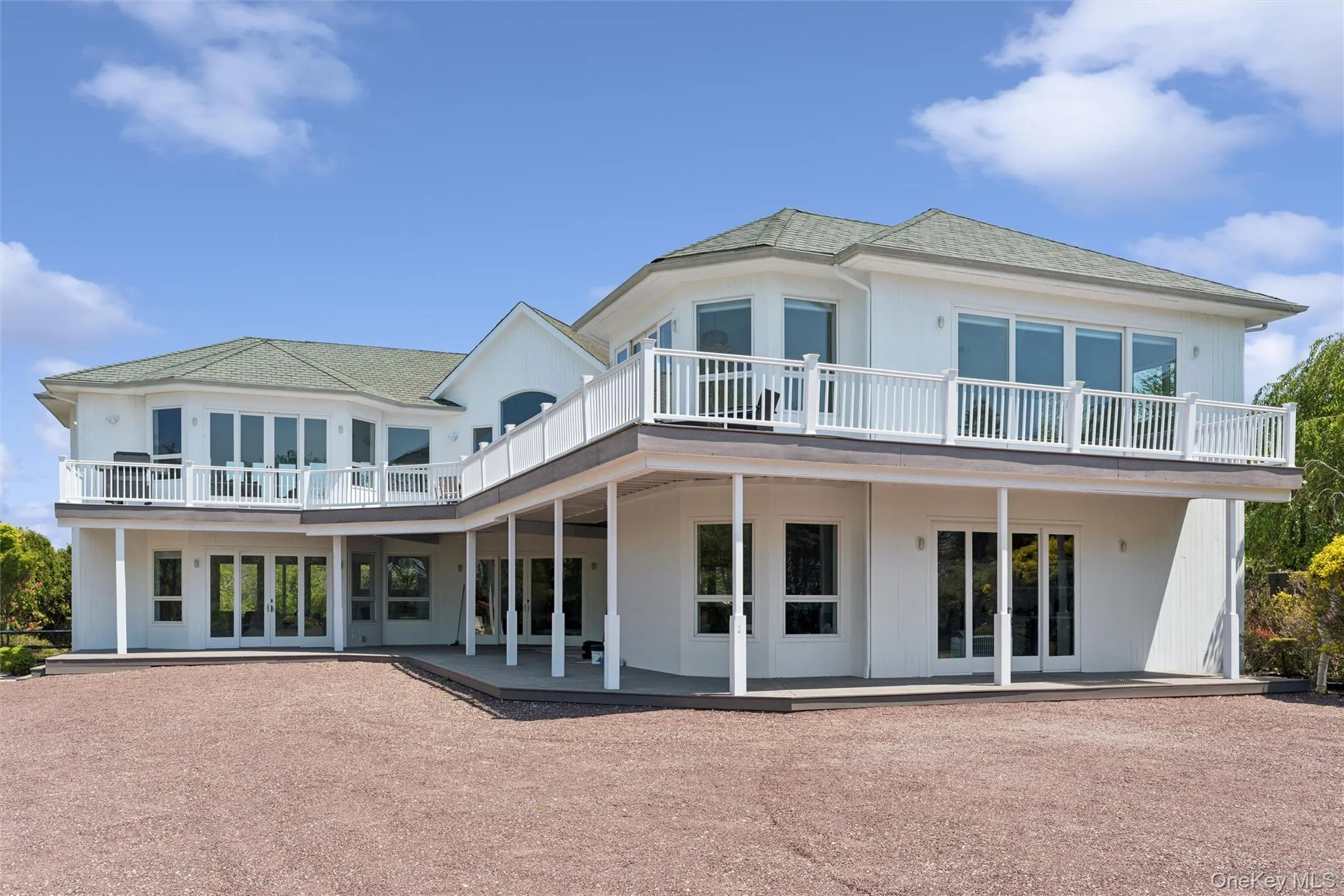 White cedar exterior with a multi-level deck and multiple glass doors White cedar exterior with a multi-level deck and multiple glass doors