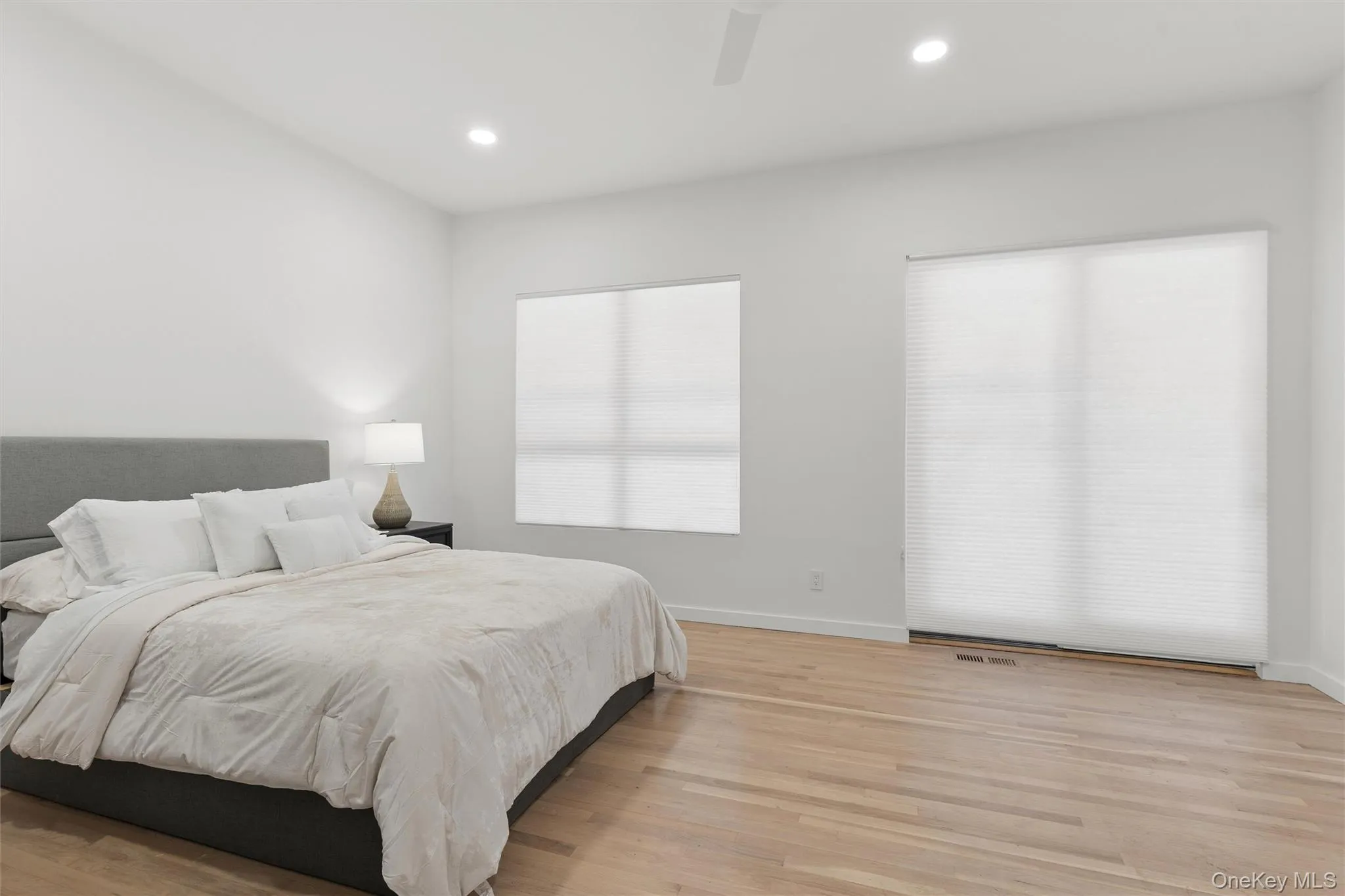 Spacious room featuring light wood-finish flooring, recessed lighting, and a ceiling fan, sliding doors to deck, Spacious room featuring light wood-finish flooring, recessed lighting, and a ceiling fan, sliding doors to deck,