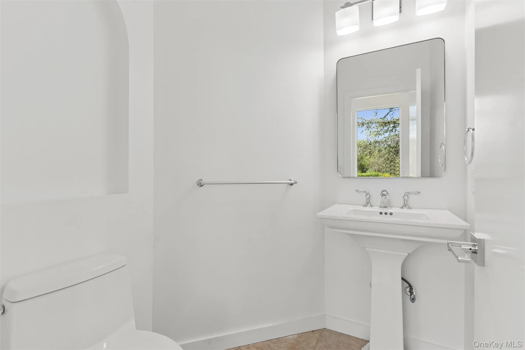1st Floor Powder Room with Pedestal sink, chrome fixtures and an overhead vanity light 1st Floor Powder Room with Pedestal sink, chrome fixtures and an overhead vanity light