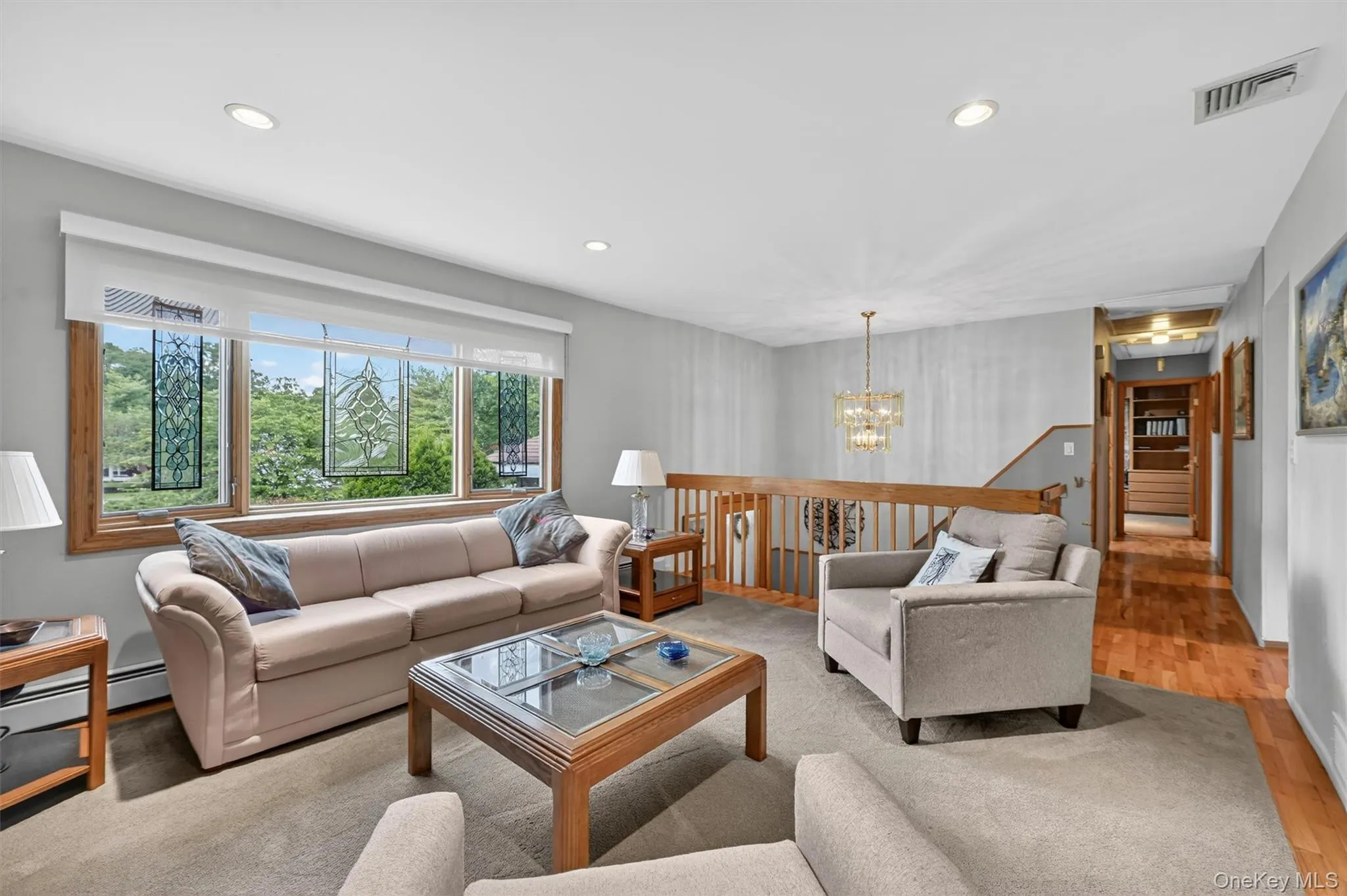 Spacious living room offering comfortable gathering space, neutral décor, and expansive front-facing views through the oversized window. Spacious living room offering comfortable gathering space, neutral décor, and expansive front-facing views through the oversized window.