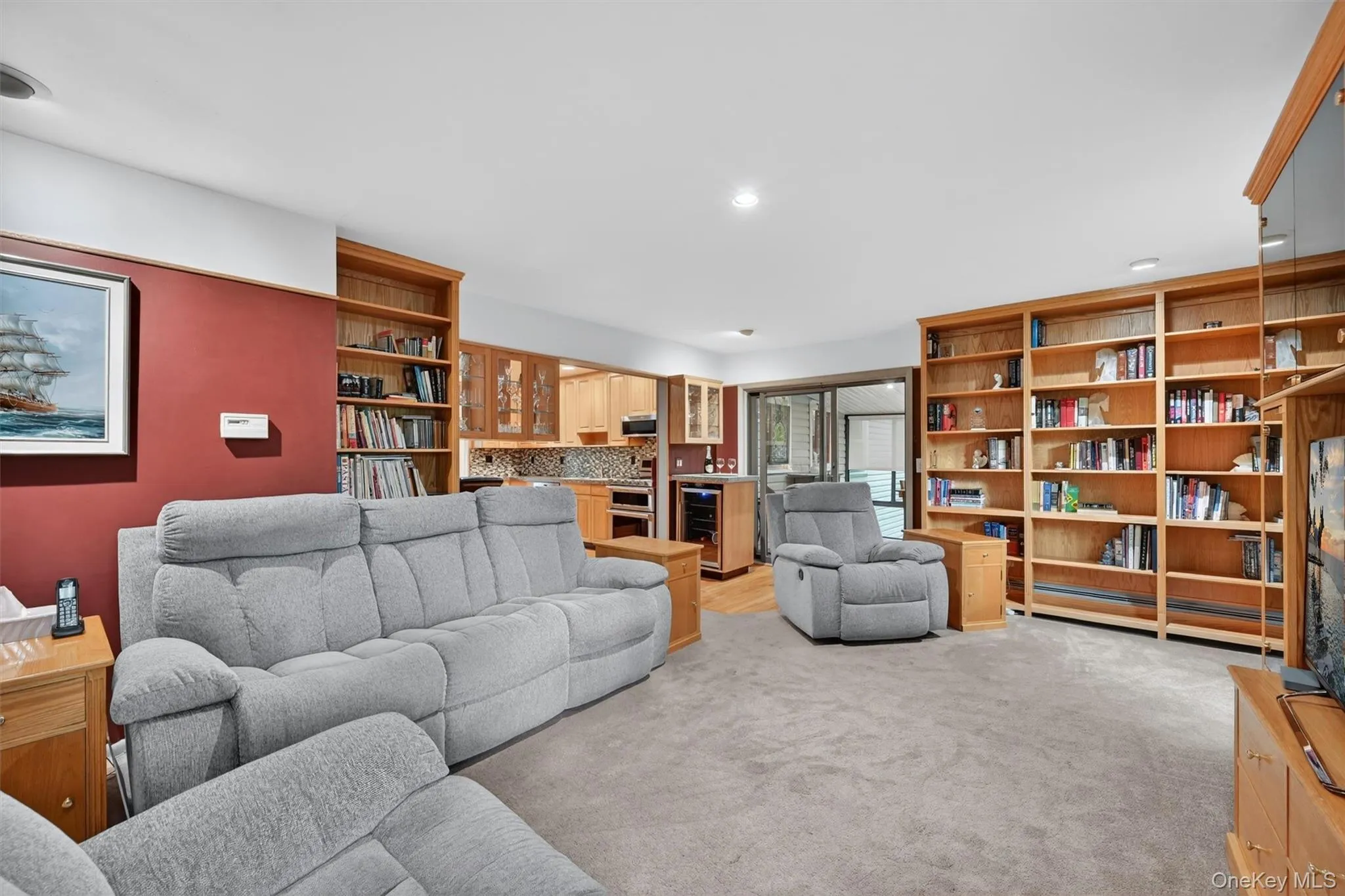 Expansive family room featuring custom built-in shelving, generous gathering space, and a warm, inviting atmosphere for relaxing or entertaining. Expansive family room featuring custom built-in shelving, generous gathering space, and a warm, inviting atmosphere for relaxing or entertaining.