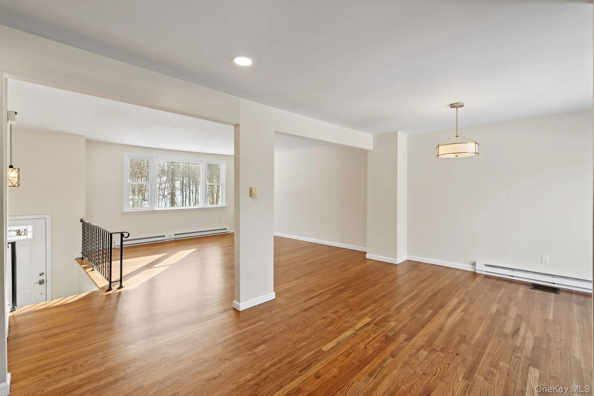 Basement with a baseboard radiator and hardwood / wood-style floors Basement with a baseboard radiator and hardwood / wood-style floors