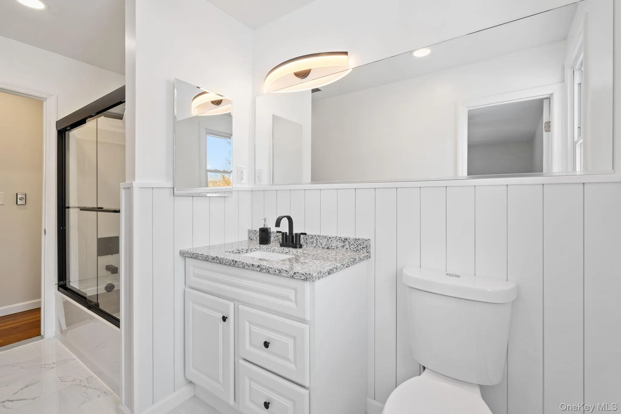 Full bathroom featuring enclosed tub / shower combo, vanity, and toilet Full bathroom featuring enclosed tub / shower combo, vanity, and toilet