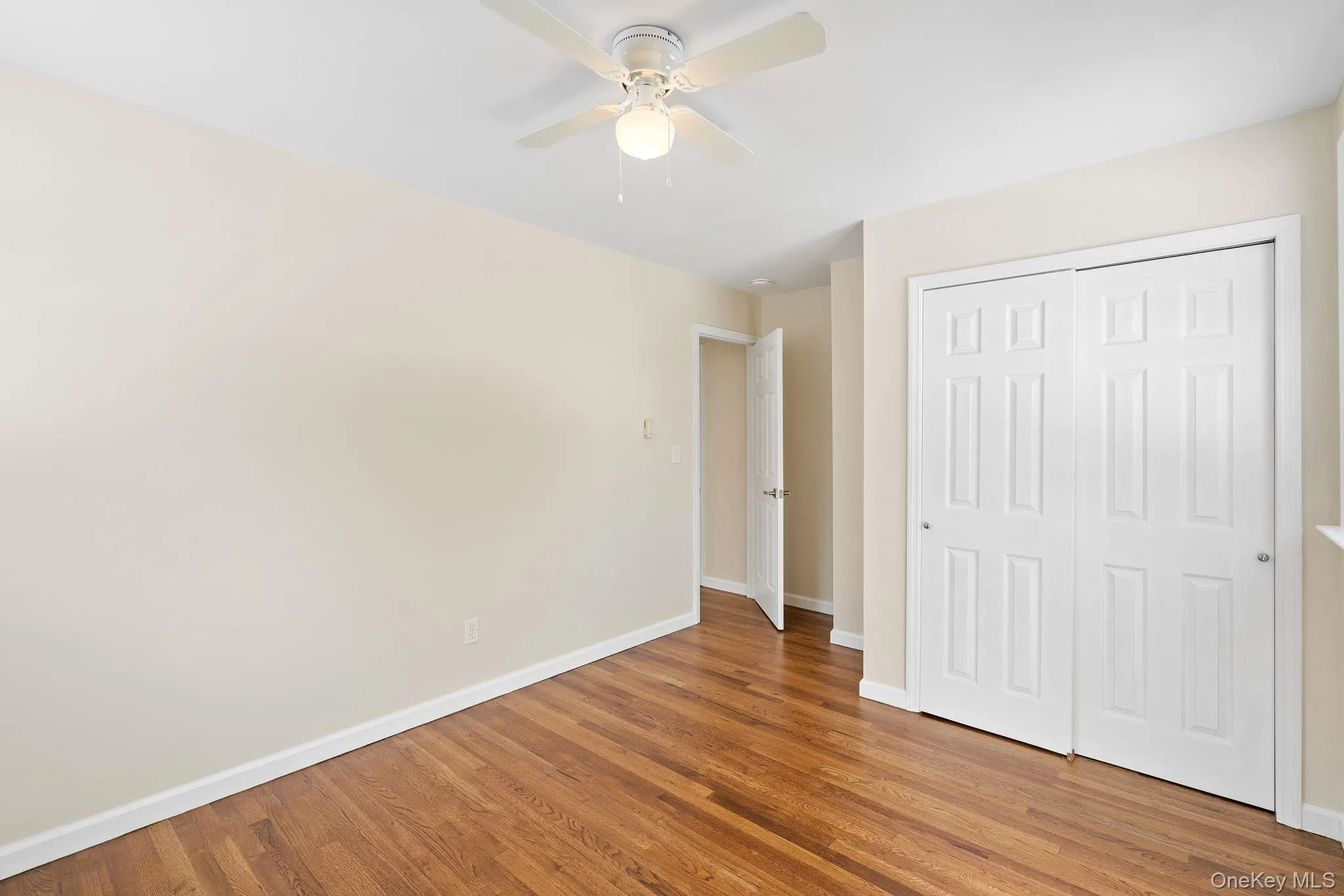 Unfurnished bedroom with hardwood / wood-style floors, a closet, and ceiling fan Unfurnished bedroom with hardwood / wood-style floors, a closet, and ceiling fan