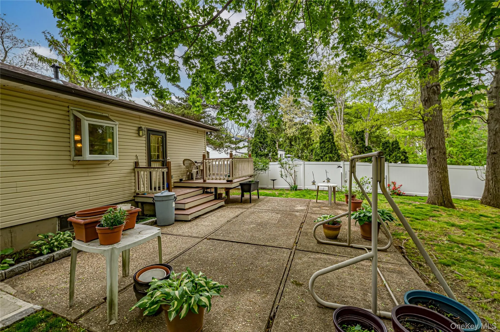 Expansive concrete patio with a multi-level wood deck and exterior access Expansive concrete patio with a multi-level wood deck and exterior access