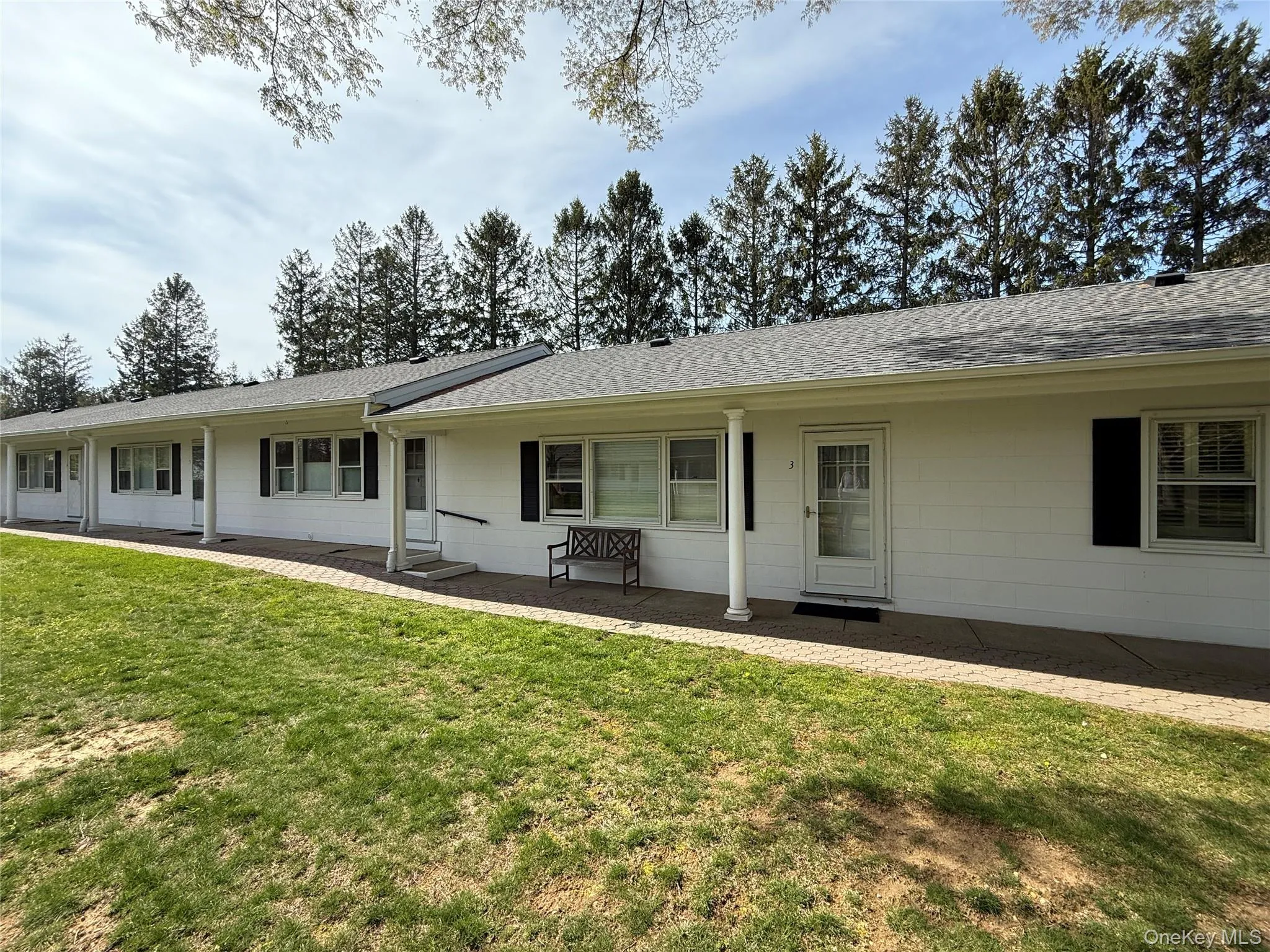 Back of property featuring a lawn, a patio, and a shingled roof Back of property featuring a lawn, a patio, and a shingled roof