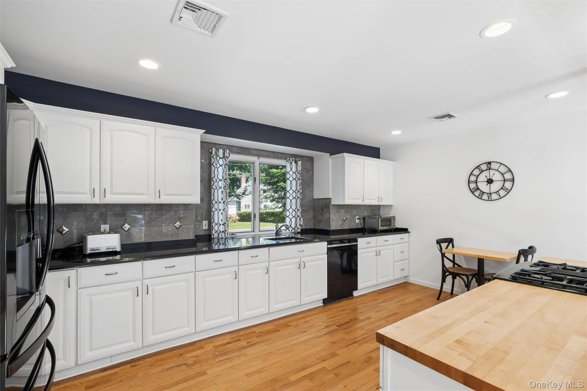 Bright and white kitchen cabinets and granite counter tops -plenty of counter space Bright and white kitchen cabinets and granite counter tops -plenty of counter space