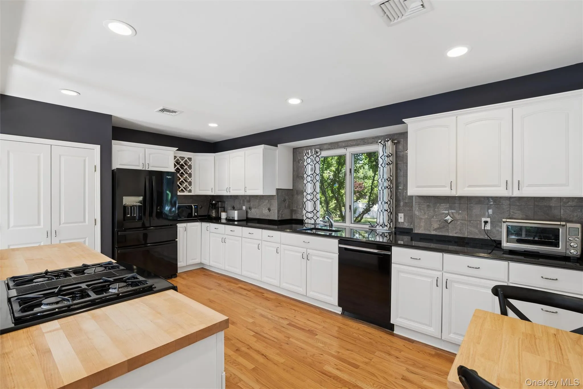 Bright and white kitchen cabinets, granite counter tops and butcher block counter for all your cooking needs Bright and white kitchen cabinets, granite counter tops and butcher block counter for all your cooking needs