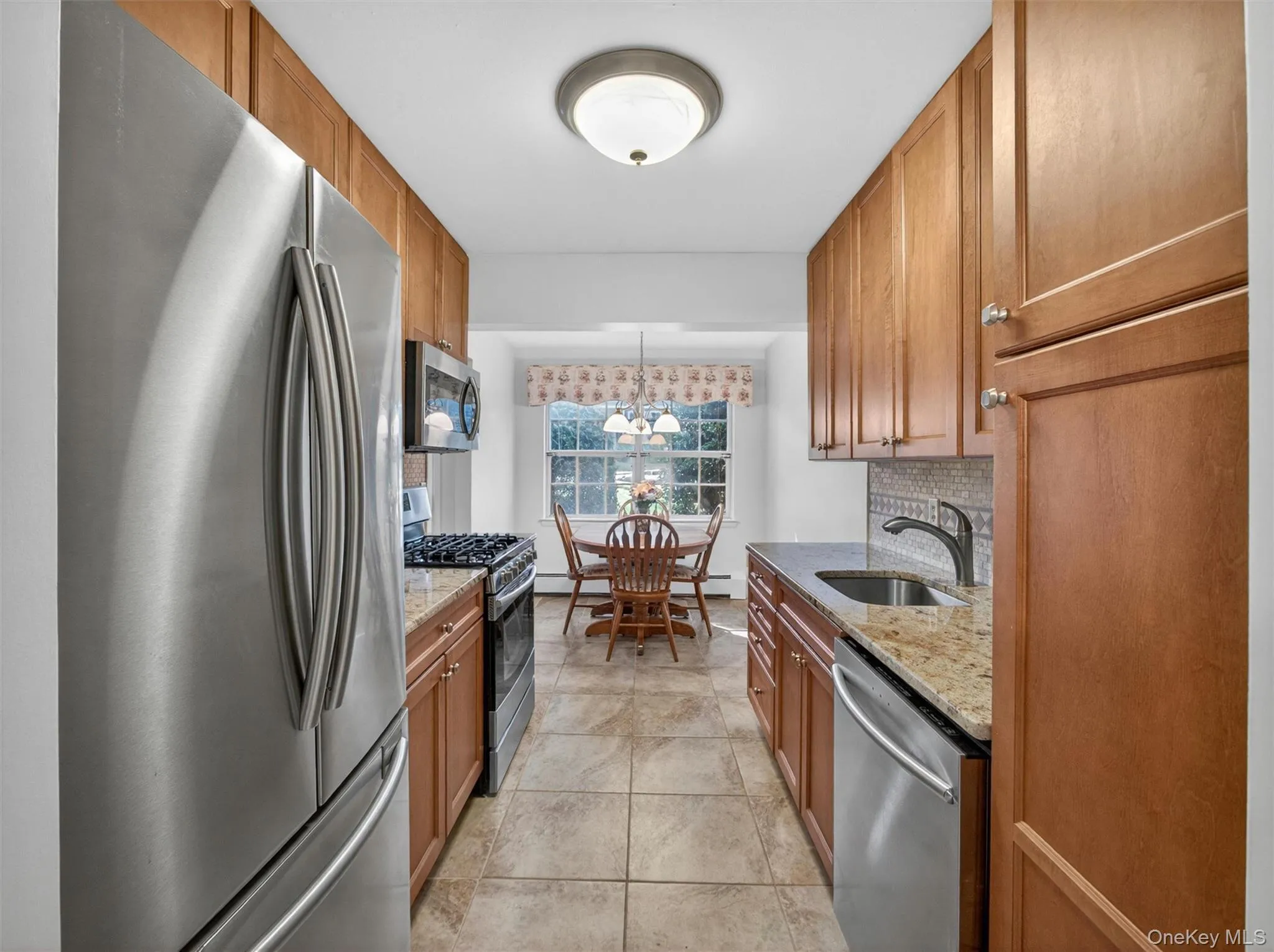 Kitchen featuring stainless steel appliances, abundant cabinetry, and a natural flow to the dining area. Kitchen featuring stainless steel appliances, abundant cabinetry, and a natural flow to the dining area.