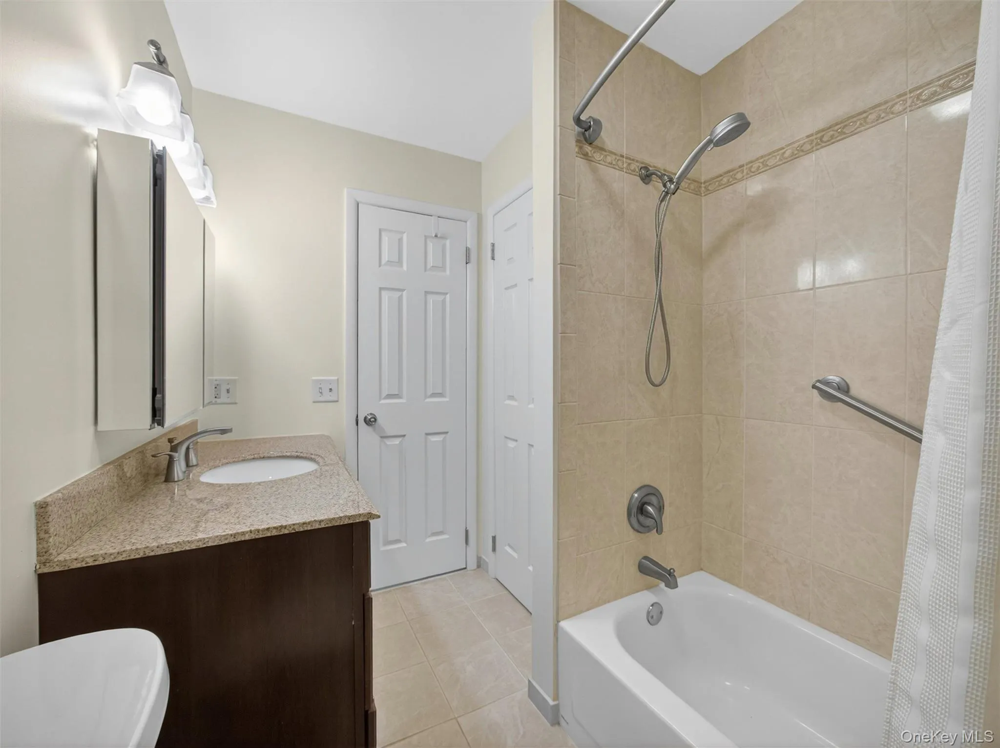 Full hall bathroom featuring a tub/shower combination and generous vanity storage. Full hall bathroom featuring a tub/shower combination and generous vanity storage.
