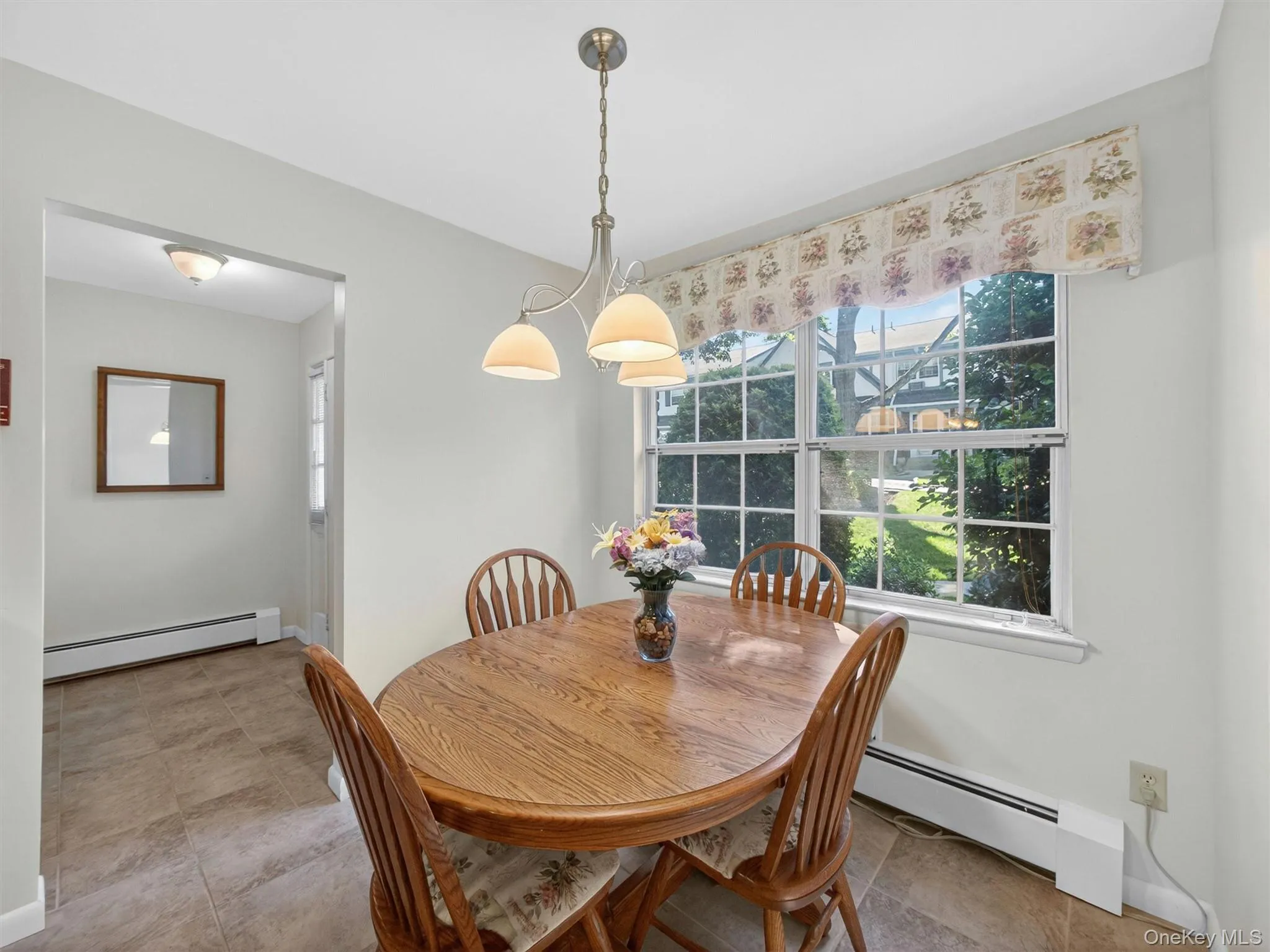 Bright dining area featuring a large window overlooking the beautifully landscaped courtyard. Bright dining area featuring a large window overlooking the beautifully landscaped courtyard.